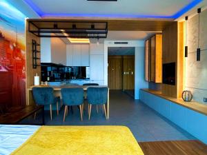 a kitchen with a table and some blue chairs at EASY RENT Apartments- Unia Art Residence 130, Basen & SPA, Centrum Free Parking 24h Check-in in Lublin