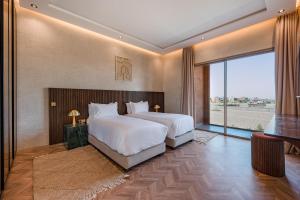 a bedroom with two beds and a large window at Villa Nabil byTheCasaEdition in Marrakech +74 photos