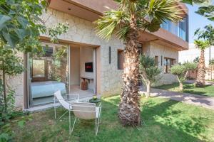 a house with a palm tree in the yard at Villa Nabil byTheCasaEdition in Marrakech