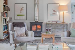a living room with two chairs and a wood stove at Gins Barn in Southampton