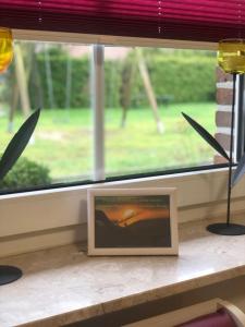 a picture sitting on a window sill with a picture frame at Schöne Auszeit RE14 in Sögel