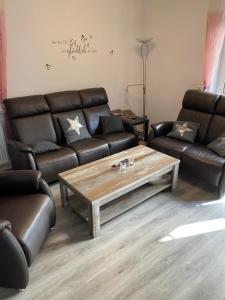 a living room with leather couches and a coffee table at Schöne Auszeit RE14 in Sögel