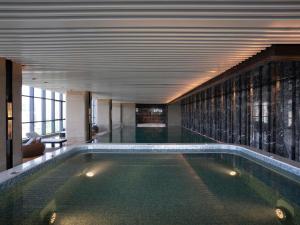 a swimming pool in a building with a ceiling at Pullman Suzhou Zhonghui in Suzhou