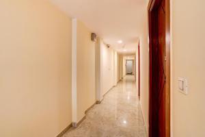 a hallway with white walls and a long corridor at Hotel O Red Diamond Hotel in Ghaziabad