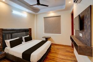 a bedroom with a bed and a flat screen tv at Hotel O Red Diamond Hotel in Ghaziabad +22 photos