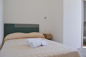 una camera da letto con un letto con due asciugamani sopra di La Piazzetta Affittacamere a Ghilarza