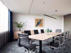 a conference room with a wooden table and chairs at Mantra Melbourne Epping in Epping