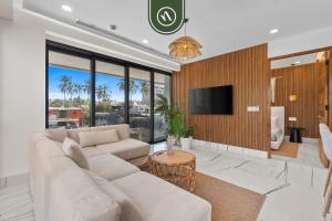 a living room with a couch and a tv at Luxury 2 BR Condo with Dream Pools - Beach - Art in Bucerías