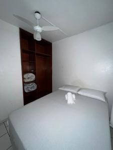 a bedroom with a white bed with a ceiling fan at Dubai in Balneário Camboriú +10 photos