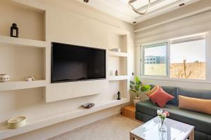 a living room with a flat screen tv on a wall at APT-Cinema Pool-Free Parking-Gym-Netflix in El Jadida