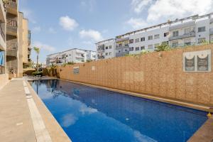 a large blue swimming pool next to a brick wall at APT-Cinema Pool-Free Parking-Gym-Netflix in El Jadida