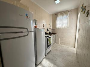 a kitchen with a refrigerator and a stove at Canto do Forte: conforto, Wi-Fi e garagem! in Praia Grande