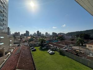 a view of a city with buildings and a green yard at Canto do Forte: conforto, Wi-Fi e garagem! in Praia Grande