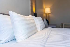a white bed with white pillows on top of it at Dorma Coliseum in Santander