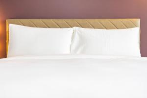 a bed with white pillows in a hotel room at Dorma Coliseum in Santander