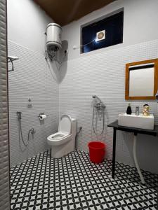 a bathroom with a toilet and a sink and a shower at Chamba Nest in Chamba