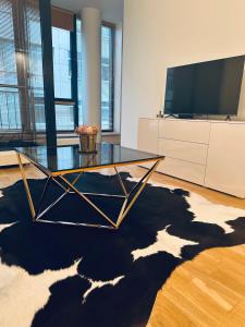 a living room with a glass table and a tv at Žvėrynas Apartment with jacuzzi in Vilnius