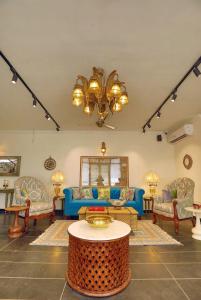 a living room with a blue couch and a table at Madhukar Vilas in Vrindāvan
