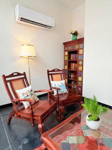 a living room with two chairs and a fan at Madhukar Vilas in Vrindāvan