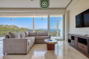 a living room with a couch and a tv at Oceanview 2 BR Condo in Punta Mita - Beach - Pool in Higuera Blanca