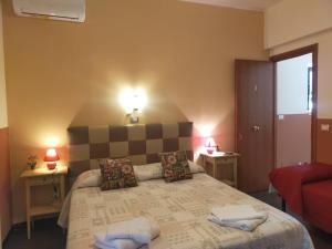 a bedroom with a large bed with two tables and two lamps at Bed & Breakfast Hostel H24 in Ragusa