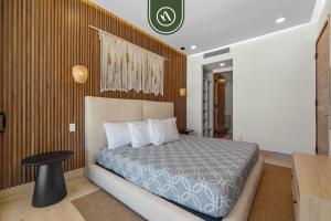 a bedroom with a bed and a wooden wall at Luxury 2 BR Condo with Dream Pools - Beach - Art in Bucerías +47 photos