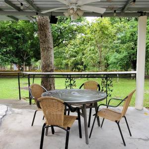une table et des chaises sur une terrasse avec un arbre dans l'établissement cozy corner with pool minutes away from the beach, à La Paz
