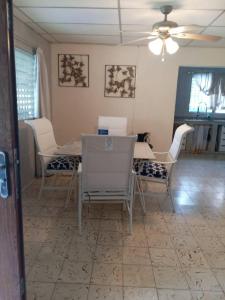 a dining room with a table and white chairs at cozy corner with pool minutes away from the beach in La Paz