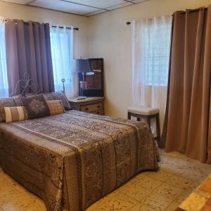 a bedroom with a bed and a table and windows at cozy corner with pool minutes away from the beach in La Paz