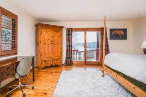 una camera da letto con un letto, una scrivania e una finestra di Monthly or Seasonal Large Petite Lake 44 Lakehouse Retreat with Private Pier and Hot Tub secluded Deep in the Woods a Fox Lake