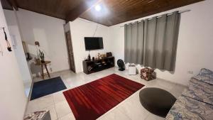 a living room with a television and a red rug at Chácara Bella Vista Mairinque in Mairinque