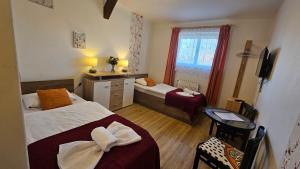 a hotel room with two beds and a window at Penzion Alfa Poděbrady in Poděbrady