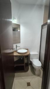 a bathroom with a white toilet and a sink at Selvamar 402 in Playa del Carmen