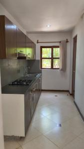 an empty kitchen with a stove and a window at Selvamar 402 in Playa del Carmen