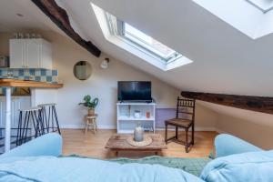 a living room with a couch and a tv at Le Grenier - Blois hyper centre in Blois