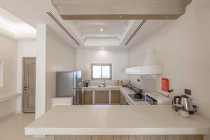 eine Küche mit weißen Wänden und einer weißen Decke in der Unterkunft Mabaat-Jasmine Greek Villa 4BR- 583 Villa 9 in Dschidda