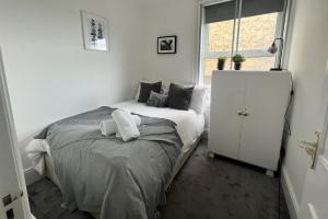a bedroom with a bed and a white cabinet at Seaview 2 Bedroom House Sleeps 5 -Pets Ok -WiFi in Shoreham-by-Sea