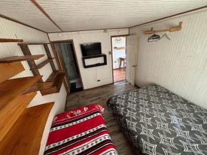 a small room with a bed and a couch in it at Cabañas fariña in Llanquihue
