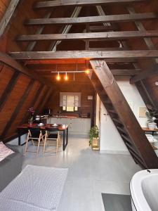 an attic kitchen and dining room with a wooden ceiling at Chalé Alvorada dos Pássaros in Canelinha