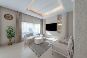 a living room with a couch and a tv at Mabaat-Jasmine Greek Villa 4BR- 583 Villa 16 in Jeddah