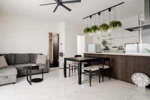 a kitchen and living room with a table and a couch at Dual Life House Koza in Okinawa City