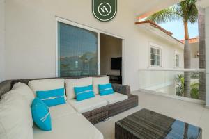 - un salon avec un canapé blanc et des oreillers bleus dans l'établissement 2BR Condo in Acapulco with Private Patio - Pool, à Acapulco