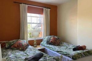 a room with two beds and a window at Glastonbury 2-Bed House Sleeps 6 & Pet Friendly in Glastonbury