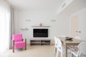 サン・アントニオ・ベイにあるBA Style Apartments Ibizaのリビングルーム(テーブル、ピンクの椅子付)