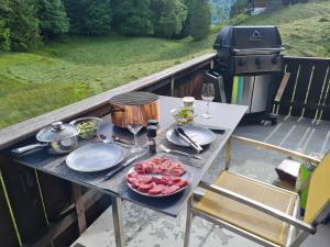 a picnic table with food and wine glasses and a grill at ABO - Boutique Apartment - Chalet Grindelwaldgletscher in Grindelwald