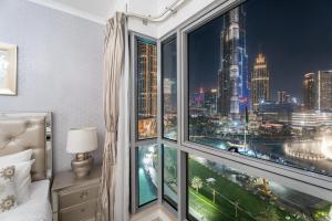 a bedroom with a large window with a city view at GuestReady - Charming stay with Burj Khalifa views in Dubai +51 photos