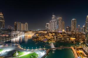 a city skyline at night with a river and buildings at GuestReady - Charming stay with Burj Khalifa views in Dubai