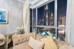 a living room with a couch and a large window at GuestReady - Charming stay with Burj Khalifa views in Dubai