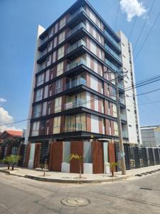 a tall building on the corner of a street at new apartment in Cochabamba +15 photos