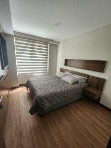 a bedroom with a bed and a large window at new apartment in Cochabamba